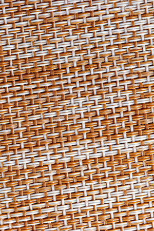 A woven fabric with a brown and white pattern. The texture is rough and the colors are warm and invitingの写真素材