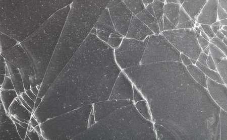 A black and white photo of a broken glass. The photo is of a shattered glass that has been broken...