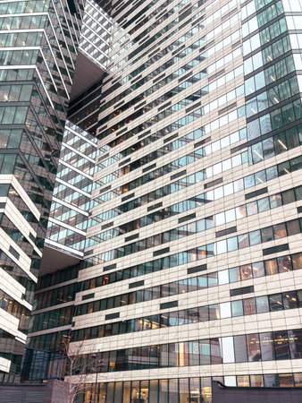 A tall building with many windows and a reflection of the building in the windows. The building is...