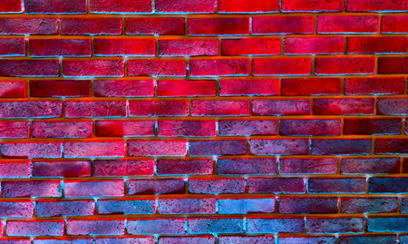 A brick wall with a red and blue color scheme. The wall is painted in a way that it looks like it is glowingの写真素材
