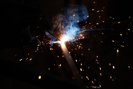 A bright blue flame is shooting out of a metal object. Concept of danger and excitement, as the...