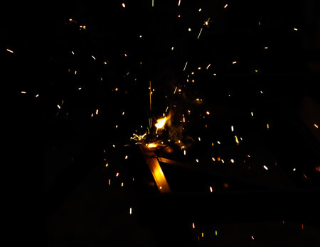 A black and white photo of a fire with sparks flying out of it. Scene is intense and dramatic