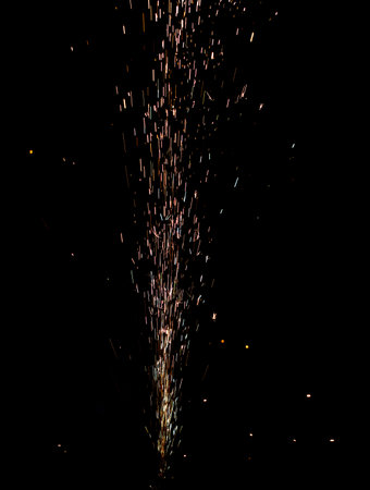 A firework display in the night sky. The fireworks are shooting up into the air and creating a...