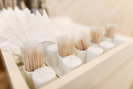 A white tray with a bunch of napkins. The napkins are folded and the containers hold sticks.の写真素材