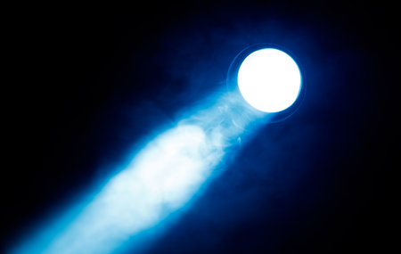 A blue light is shining on a dark background. The light is bright and creates a sense of mystery and intrigueの写真素材