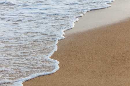 The ocean waves are crashing onto the shore, creating a beautiful and calming scene. The water is...