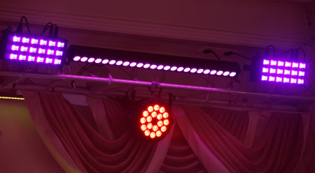 A purple and red light show is hanging from the ceiling. The lights are purple and red and are arranged in a way that creates a dynamic and energetic atmosphereの写真素材