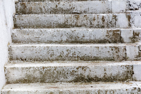 The stairs are dirty and worn, with a lot of grime and dirt on them. The steps are white and the grime is brownの写真素材