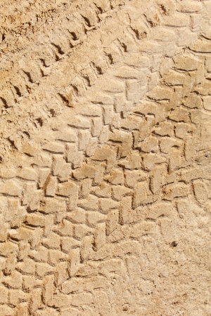 A tire track is shown in a sandy area. The tire track is a series of zigzags that are spread out across the sand. The tire track is a reminder of the tire's journey and the path it has takenの写真素材