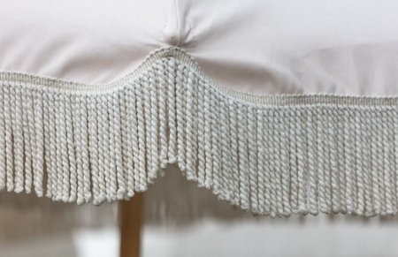 A white and tan blanket with fringes on it. The fringes are arranged in a way that they create a sense of movement and flow, giving the blanket a soft and elegant appearanceの写真素材