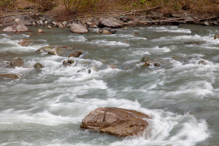 A river with fast-moving water and rocks.の写真素材