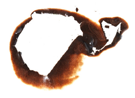 A burnt spot on a white background. The burnt spot is a dark brown colorの写真素材