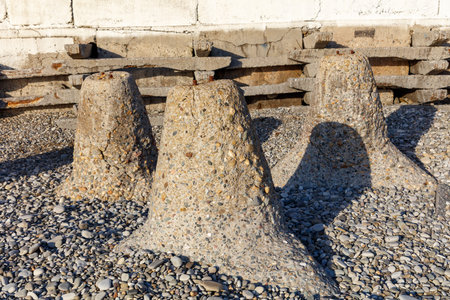 Three cement pillars are sitting on a rocky surface. The pillars are small and have a rough texture. Scene is somewhat somber and desolateの写真素材