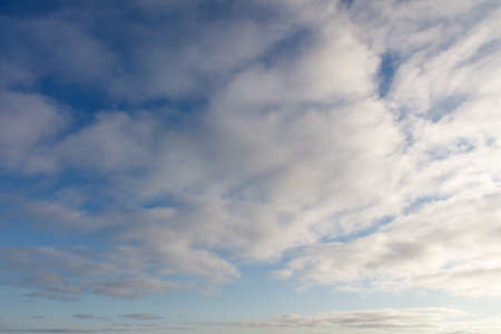 The sky is blue and cloudy. The clouds are white and fluffyの写真素材