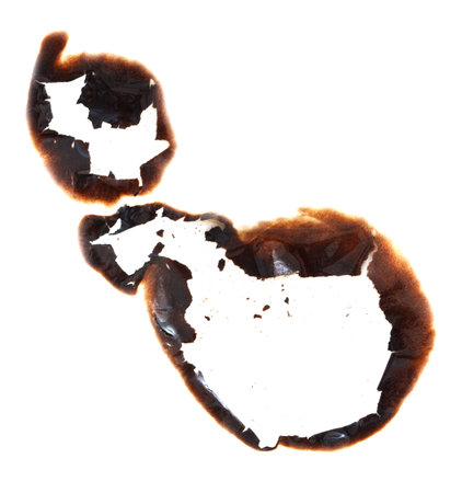 A burnt eggshell with a white egg yolk inside. The burnt shell is a reminder of the fragility of life and the impermanence of thingsの写真素材