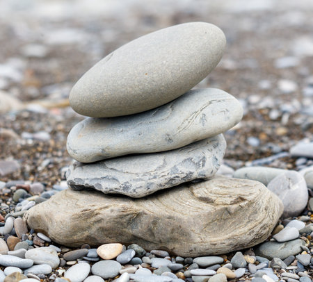 A stack of rocks on a beach. The rocks are gray and white in color. Concept of calmness and serenity