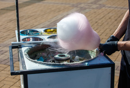 A person is blowing bubbles with a bubble machine. The bubbles are pink and the machine is on a tableの写真素材
