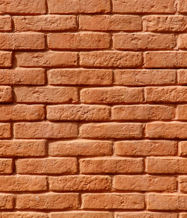 A brick wall with a brown color. The wall is made of bricks and has a rough textureの写真素材