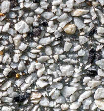 A close up of a white and black rock surface. The white rocks are scattered throughout the image, with some larger and some smaller. The black rocks are also presentの写真素材