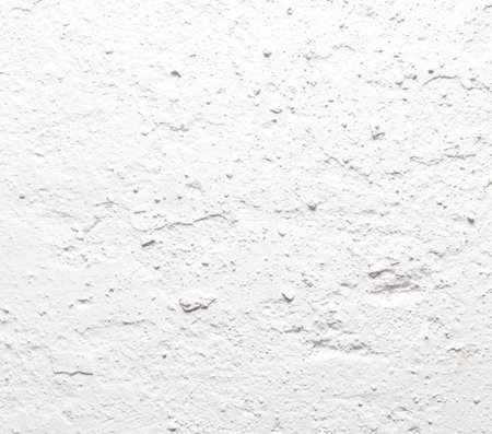 A white wall with a rough texture. The wall is covered in small white dots. The wall appears to be unfinished and unfinishedの写真素材