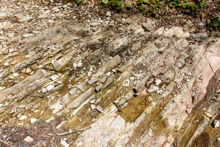 A rocky shoreline with a small body of water. The water is murky and the rocks are jaggedの写真素材