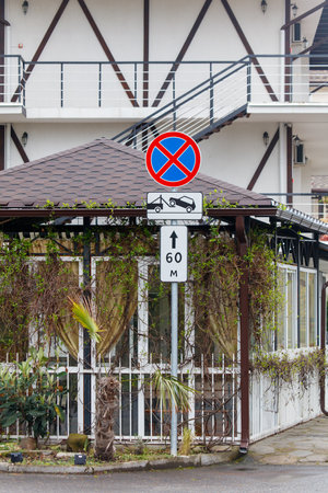A small building with a sign on it that says 60 m. The building is surrounded by vinesの写真素材