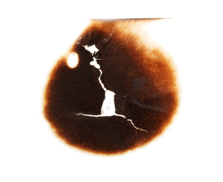 A burnt out spot on a white background. The burnt spot is in the center of the imageの写真素材