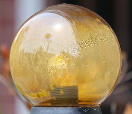 A glass sphere with a light inside of it is illuminated, creating a warm and inviting atmosphere. The light is shining through the glass, casting a soft glow on the surrounding areaの写真素材