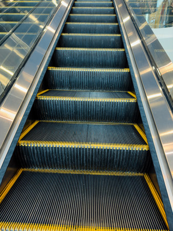 The escalator is very long and has yellow stripes. It is very shiny and looks very cleanの写真素材