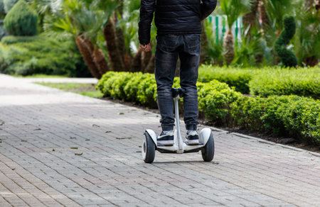 A man is riding a Segway on a brick road. Concept of freedom and adventure, as the man is able to navigate the uneven surface with easeの写真素材