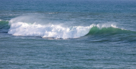 The ocean is calm and the waves are small. The water is blue and the sky is clearの写真素材