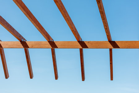 A wooden structure with a blue sky in the background. The structure is made of wood and has a slanted roofの写真素材