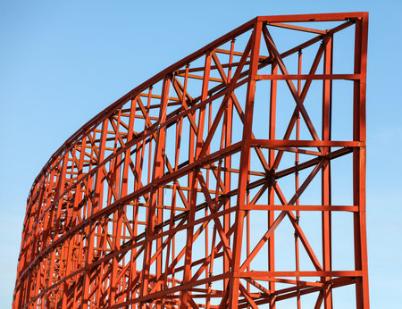 A red structure with a blue sky in the background. The structure is made of metal and has a lot of...