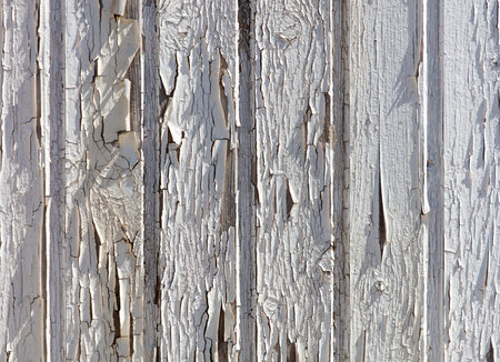 A wooden surface with a lot of peeling paint. The surface is made up of several wooden boards, and the paint is chipping off in various places. Scene is somewhat sad and wornの写真素材