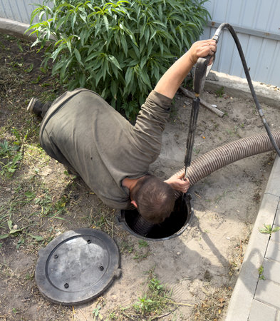 A man is working on a sewer line. Concept of hard work and dedication to the task at handの写真素材