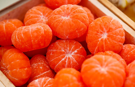 A pile of oranges in a wooden box. The oranges are all different sizes and are all orangeの写真素材