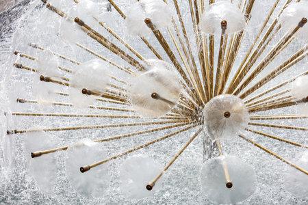 A fountain with many small white balls and wooden sticks. The water is spraying out of the sticksの写真素材