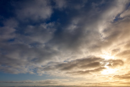 The sky is blue with a few clouds. The sun is shining through the clouds. The sky is very clear and brightの写真素材