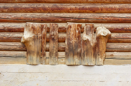 Two pieces of wood with a design on them are leaning against a wall. Scene is rustic and natural, with the wood and design giving a sense of warmthの写真素材