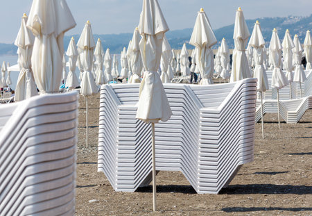 A beach scene with many white umbrellas and chairs. Scene is calm and relaxingの写真素材
