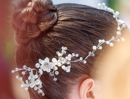 A woman with a flowery headband. The headband is made of pearls and is placed on her head