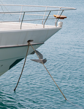 A boat is tied to the dock with a rope. The water is calm and the boat is largeの写真素材