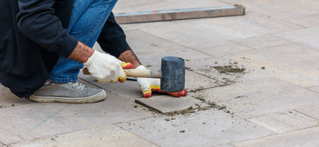 A man is using a hammer to break up concrete. Concept of hard work and determinationの写真素材