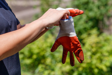 A person is wearing orange and white gloves and holding their arm out. The gloves are bright and...