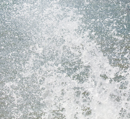 A large splash of water, with white foam and bubbles, creating a sense of movement and energy. The...
