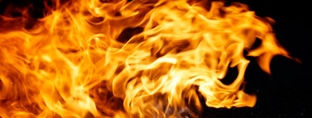 A close up of a flame with a dark background. The flame is very large and is the main focus of the...