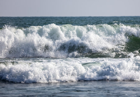 The ocean is calm and the waves are small. The water is a beautiful shade of blue. The sky is clear...