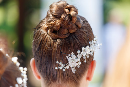 A girl with a flowery headband and a bun on her head. The bun is very high and the flowery headband...