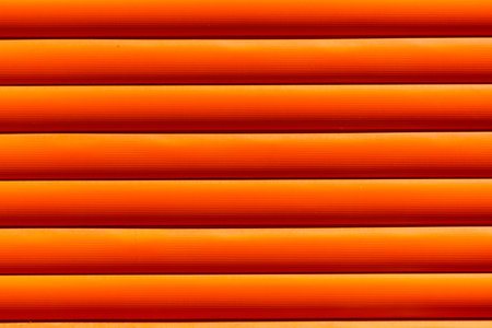 Orange wooden slats with a pattern. The slats are arranged in a row