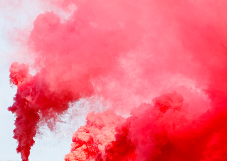 A red cloud of smoke is billowing out of a fire. The smoke is thick and red, creating a dramatic and...